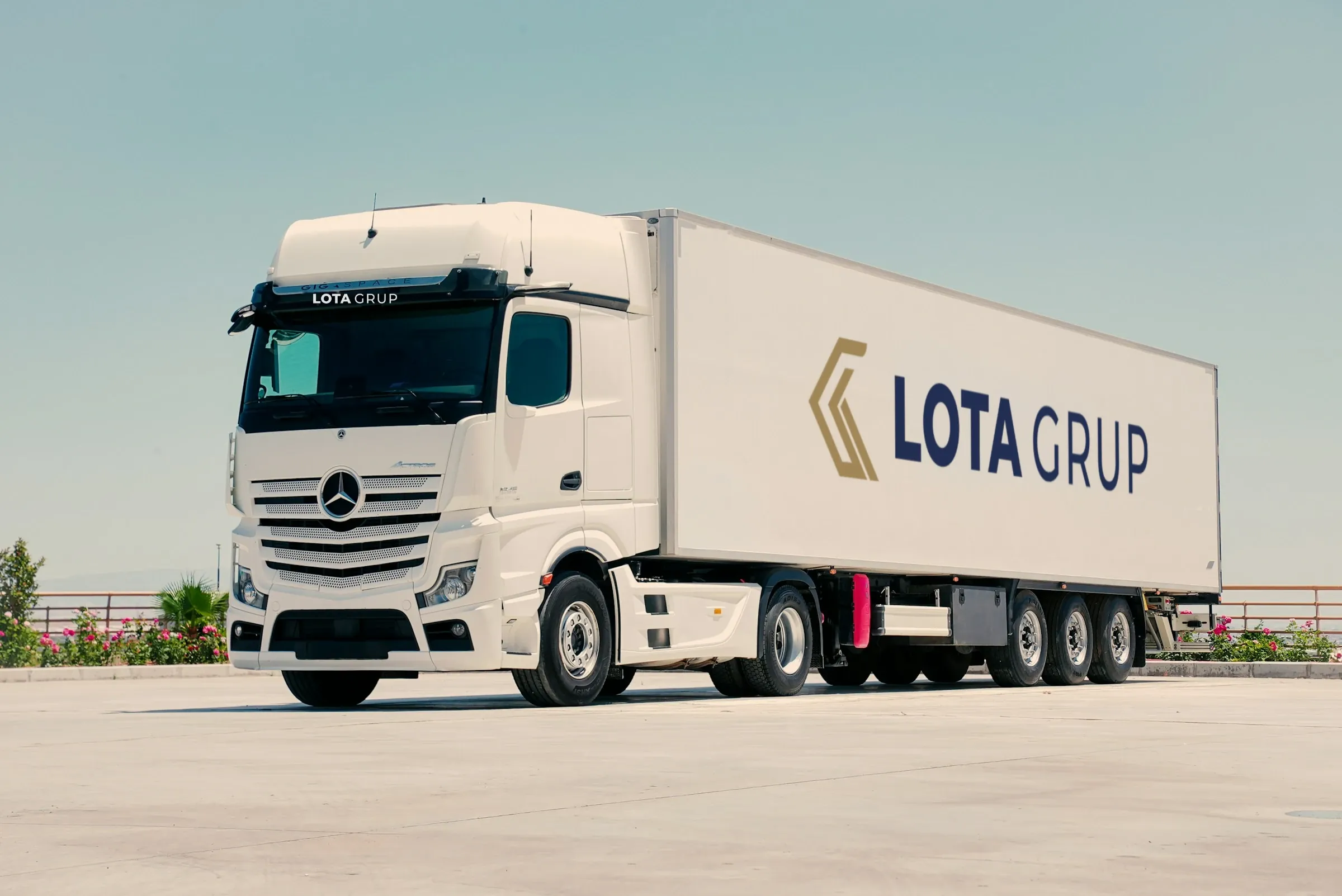 Lota Grup logolu beyaz çekici ve dorse