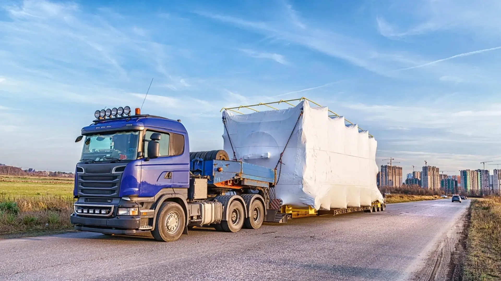 Flatbed üzerinde sabitlenmiş, brandayla korunan proje yükü